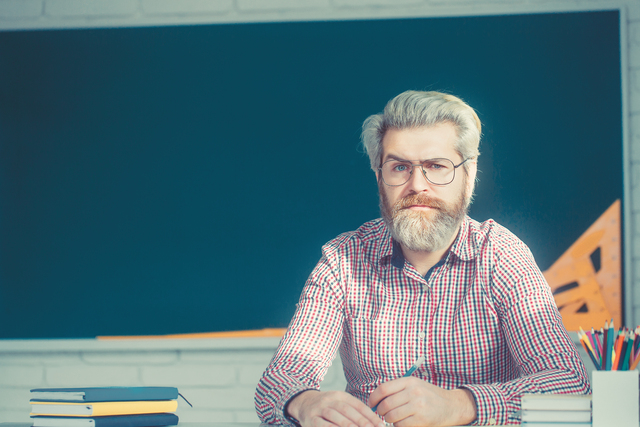 Portrait of confident Caucasian male teacher in classroom